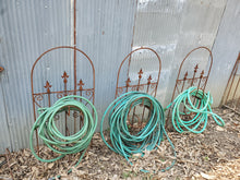 Iron Hose Wheel with 3 Finials & Stakes into the Ground